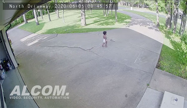 Alcom Security camera photo of kid cleaning driveway